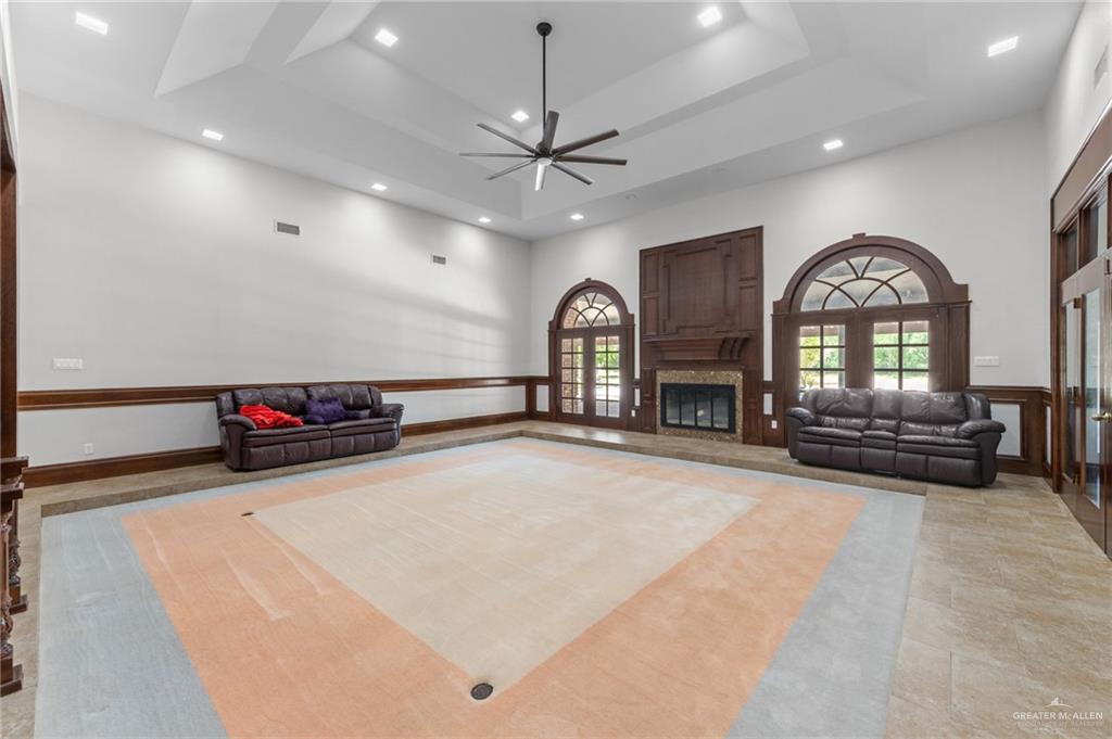 10409 North Ware Road McAllen, TX 78504 - Photo 11 of 45 a view of a livingroom with a fireplace a ceiling fan and wooden floor