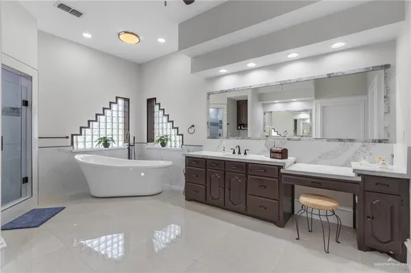 a large bathroom with a double vanity sink a mirror and a bathtub