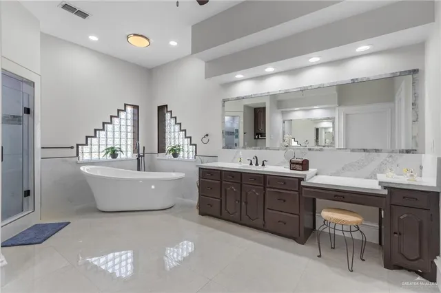 a large bathroom with a double vanity sink a mirror and a bathtub