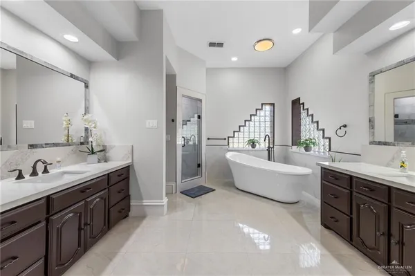 a spacious bathroom with a double vanity sink tub double and mirror