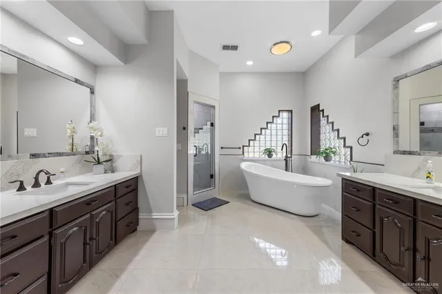 a spacious bathroom with a double vanity sink tub double and mirror
