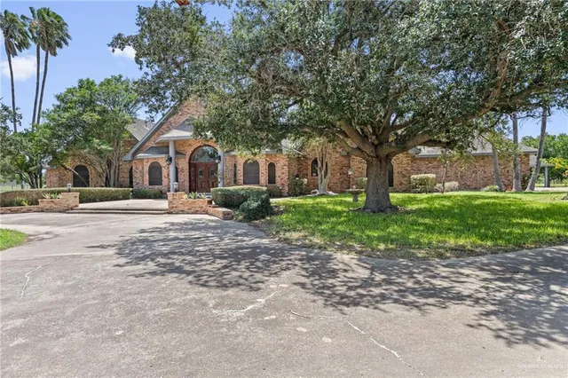 a front view of a house with a yard and trees