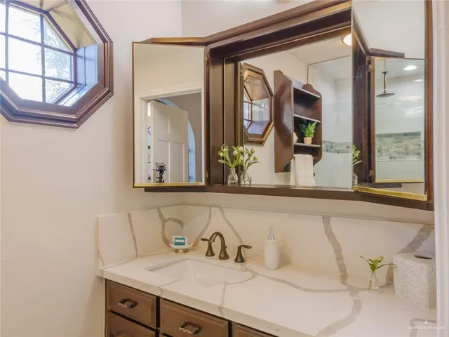 a bathroom with a granite countertop sink and a mirror