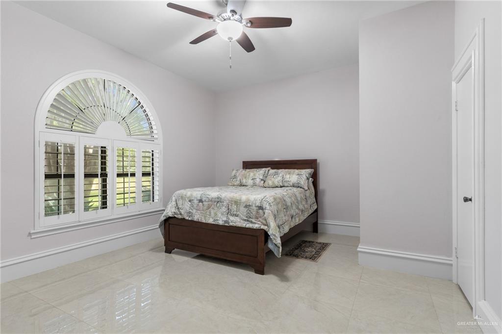 10409 North Ware Road McAllen, TX 78504 - Photo 23 of 45 a bed sitting in a spacious bedroom next to a window