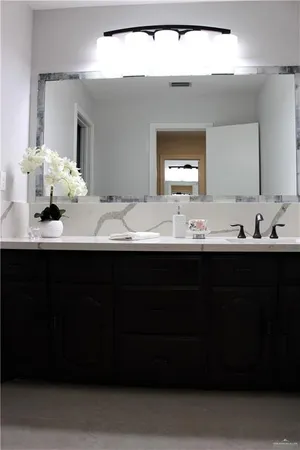 a bathroom with a sink vanity and a mirror