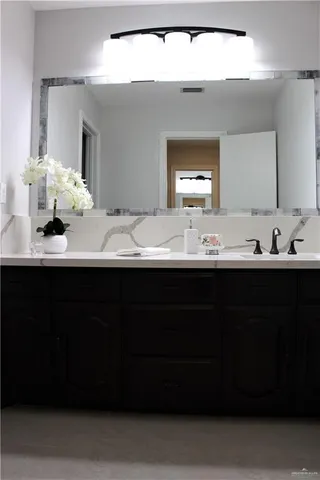 a bathroom with a sink vanity and a mirror