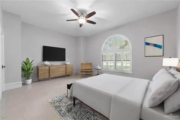 a bedroom with a bed a window and a flat screen tv