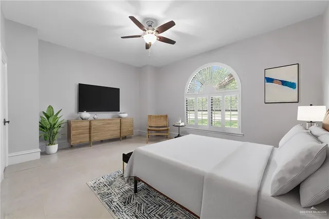 a bedroom with a bed a window and a flat screen tv