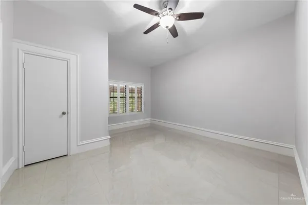 an empty room with windows and fan