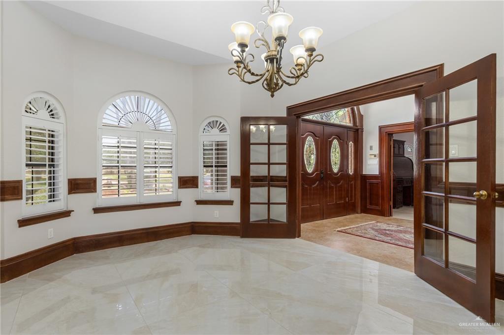 10409 North Ware Road McAllen, TX 78504 - Photo 5 of 45 a spacious bedroom with a large bed and a chandelier