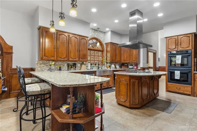 a kitchen with stainless steel appliances granite countertop a table chairs and a refrigerator