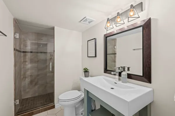 a bathroom with a toilet a sink and mirror