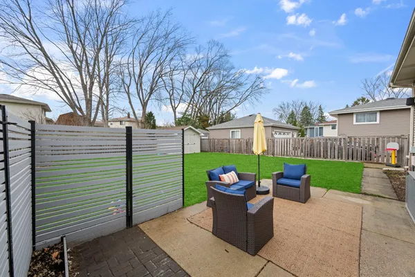 a view of a garden with furniture and wooden fence