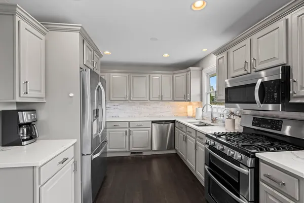 a kitchen with stainless steel appliances a sink stove and refrigerator