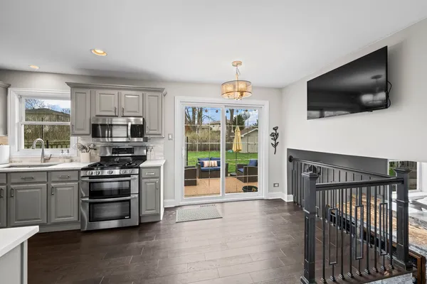 a kitchen with stainless steel appliances a stove a microwave and white cabinets