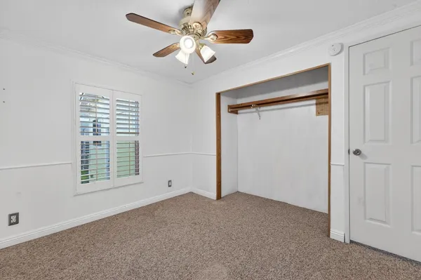 an empty room with a window and a fan