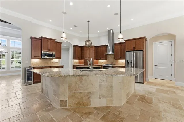 a kitchen with granite countertop a refrigerator stove and cabinets