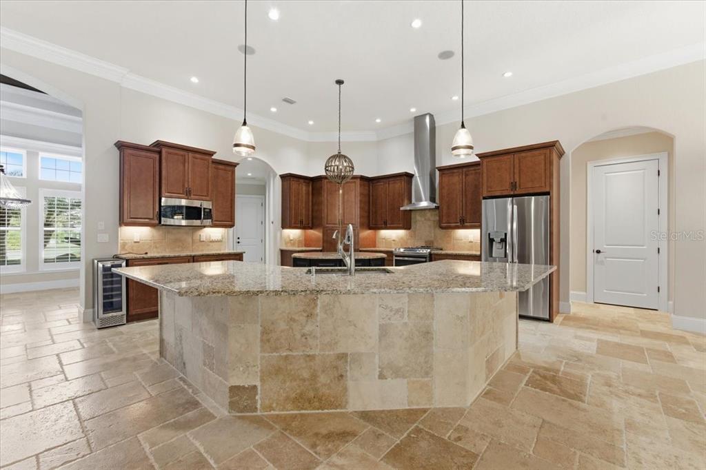 7 Spanish Moss Court Palm Coast, FL 32137 - Photo 14 of 66 a large kitchen with kitchen island stainless steel appliances a stove a sink cabinets and a counter top