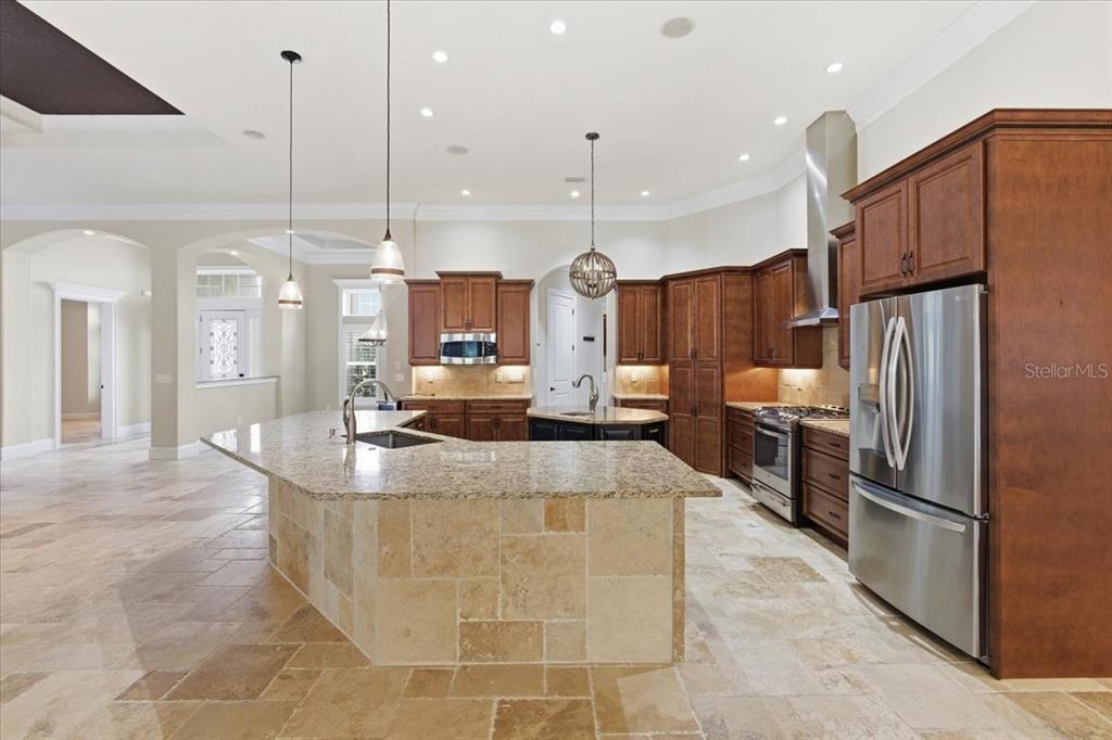 7 Spanish Moss Court Palm Coast, FL 32137 - Photo 17 of 66 a large kitchen with kitchen island a large counter top stainless steel appliances and a ceiling fan