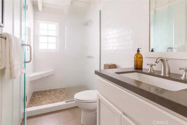 a bathroom with a granite countertop sink a toilet and shower