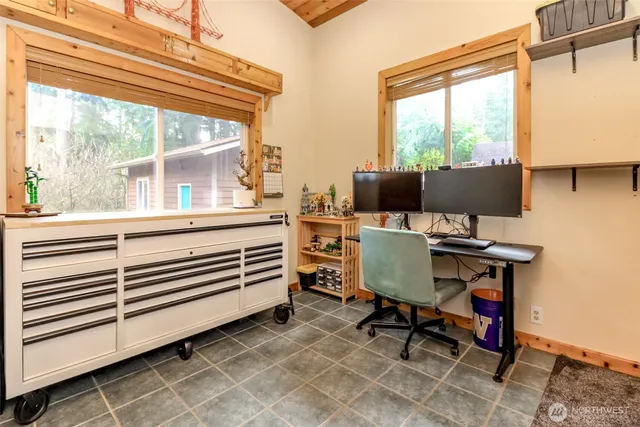 a view of a workspace with furniture and a window