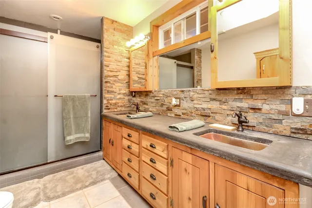 a bathroom with double sink and a mirror