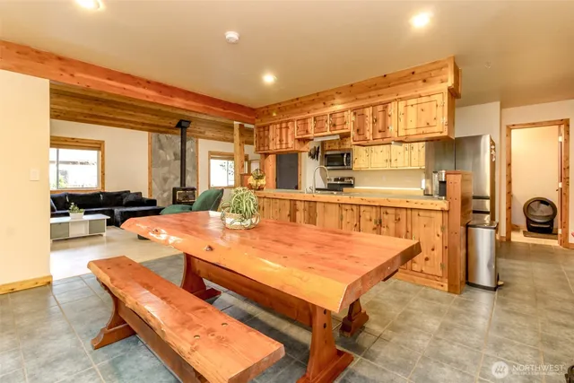 a dining hall with stainless steel appliances a dining table and chairs with wooden floor