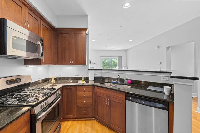 a kitchen with stainless steel appliances granite countertop a sink stove and cabinets