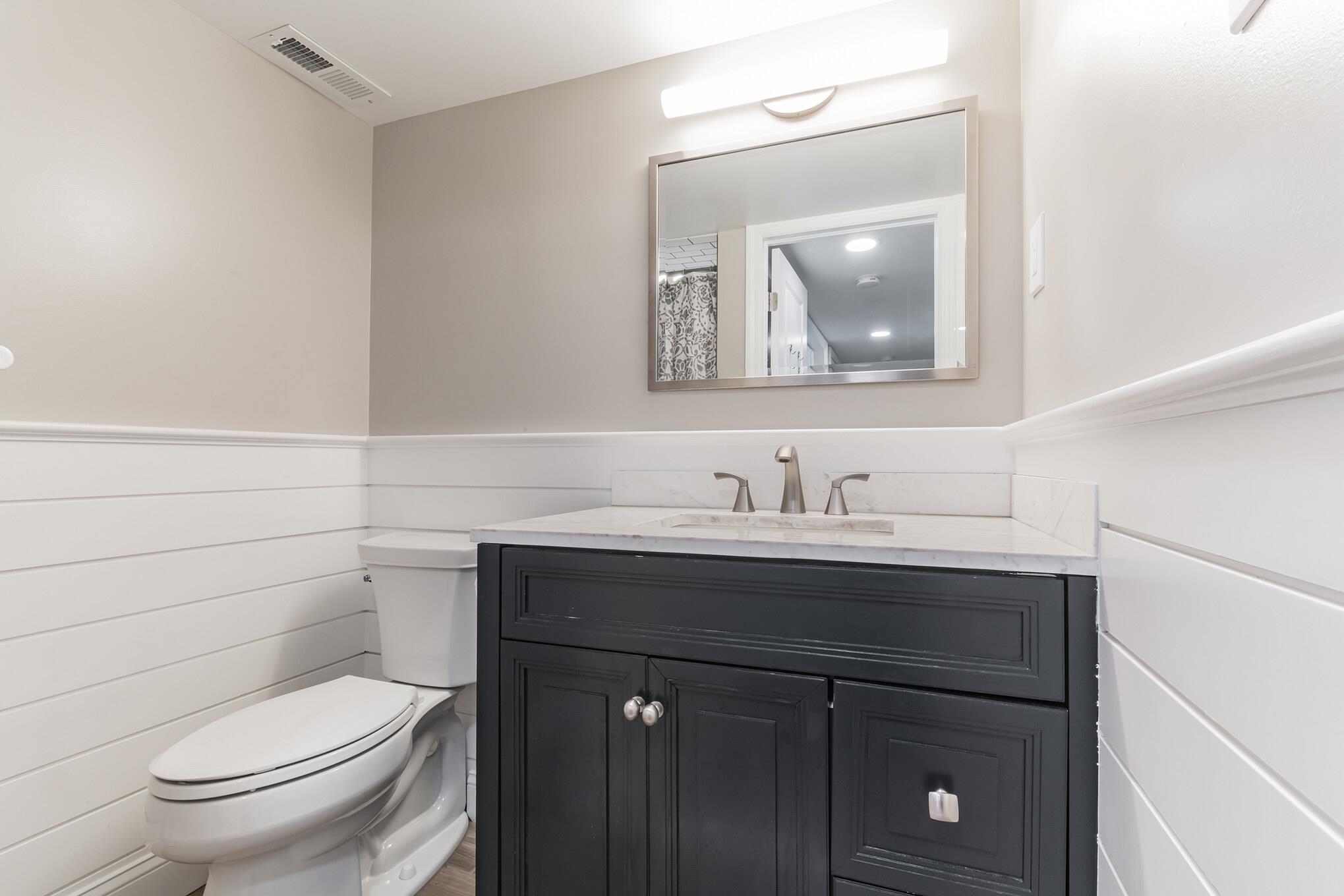 15 99th Street, Unit A Stone Harbor, NJ 08247 - Photo 23 of 41 a bathroom with a toilet sink and mirror