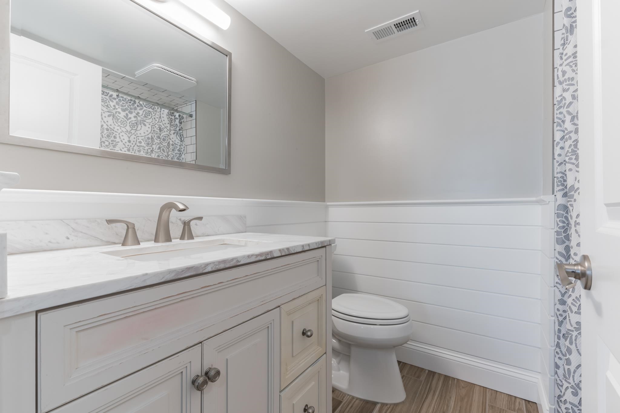 15 99th Street, Unit A Stone Harbor, NJ 08247 - Photo 28 of 41 a bathroom with a granite countertop toilet and a sink
