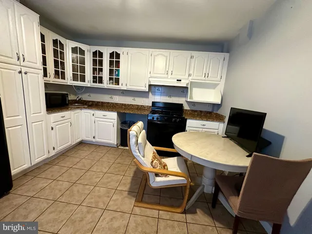 a kitchen with stainless steel appliances a dining table chairs and granite countertops
