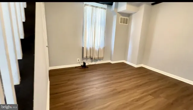 a view of a livingroom with wooden floor and a window