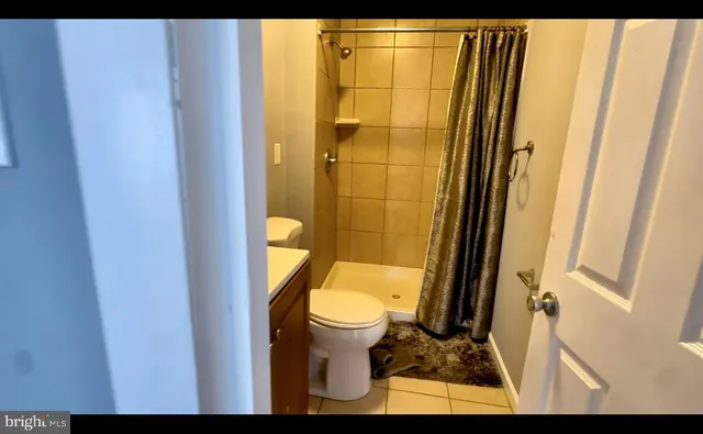 a bathroom with a toilet and a shower curtain