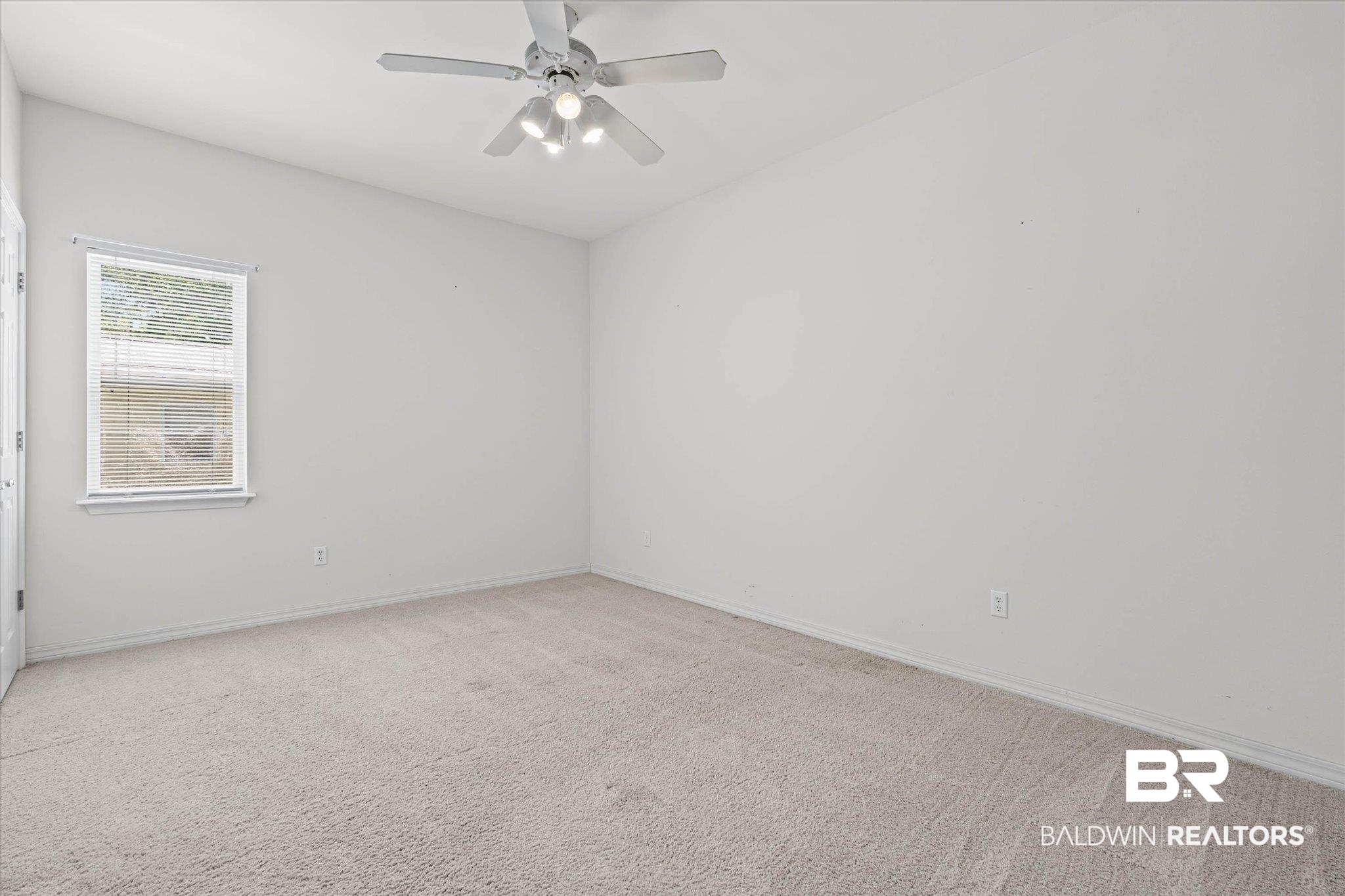 41923 Bayou Road Bay Minette, AL 36507 - Photo 20 of 35 Spacious room featuring vaulted ceilings, light-toned carpeting, a window with horizontal blinds, and a ceiling fan with integrated lighting