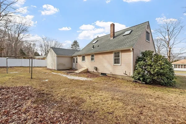 a view of a yard in front of a house with a large tree