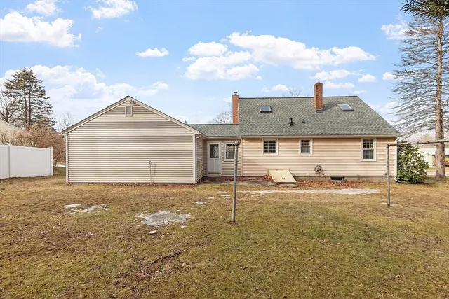 a view of a house with backyard and a tree