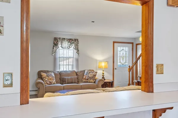 a living room with furniture and a large mirror next to a window