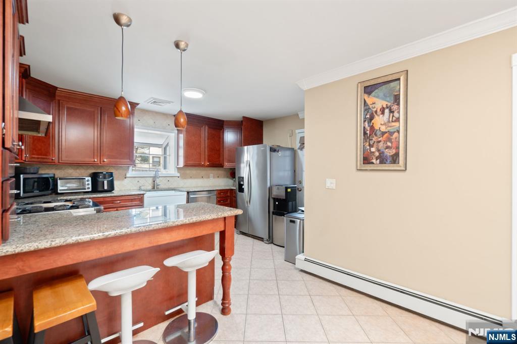 51 Anderson Avenue Englewood Cliffs, NJ 07632 - Photo 11 of 46 a kitchen with stainless steel appliances granite countertop a refrigerator a sink a stove a dining table and chairs with wooden floor