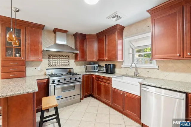 a kitchen with stainless steel appliances a sink stove and cabinets