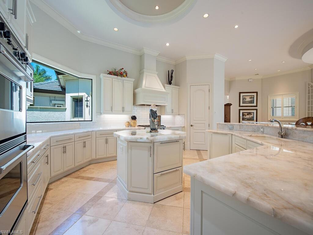 29115 Teramo Way Naples, FL 34110 - Photo 13 of 49 Kitchen w/ Illuminated Quartzite Surfaces, and center insland. large picture window and Viking appliances