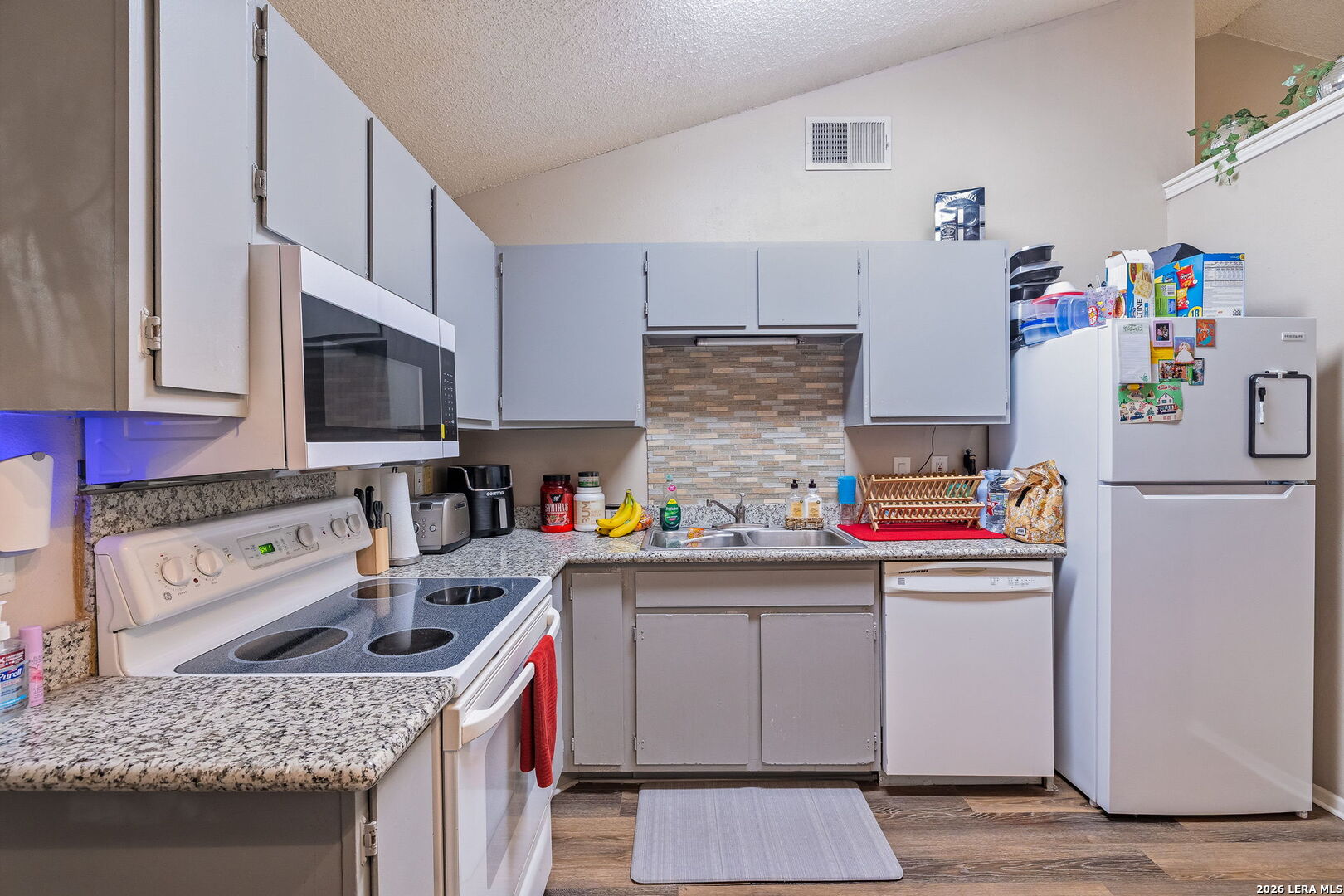9140 Timber Path, Unit 2502 San Antonio, TX 78250 - Photo 11 of 26 a kitchen with kitchen island granite countertop appliances and a sink
