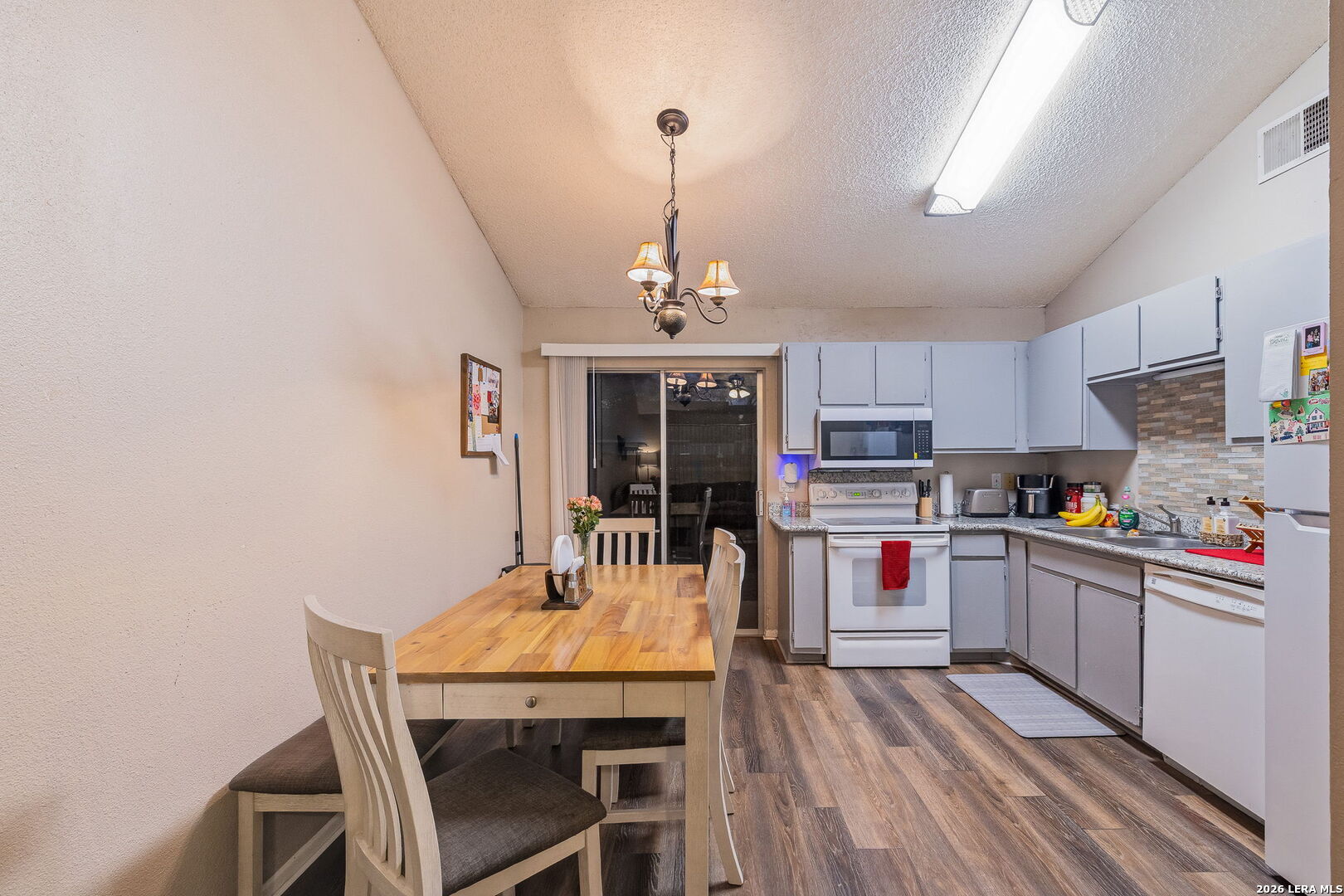 9140 Timber Path, Unit 2502 San Antonio, TX 78250 - Photo 8 of 26 a kitchen with stainless steel appliances granite countertop a dining table chairs and stove top oven
