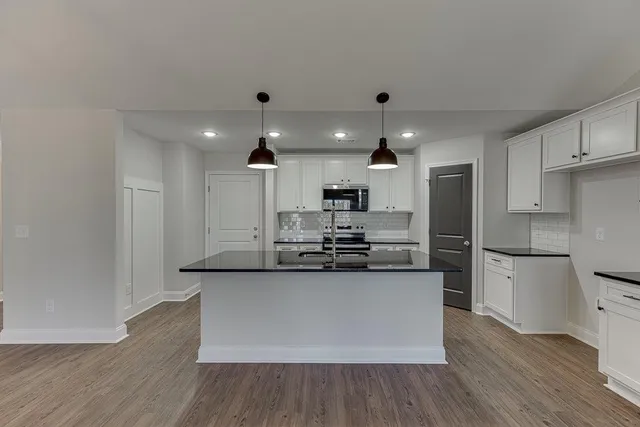 a kitchen with stainless steel appliances a refrigerator and a stove top oven
