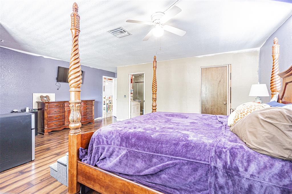 17851 Oxenham Avenue Spring Hill, FL 34610 - Photo 17 of 31 a bedroom with a bed and a chandelier