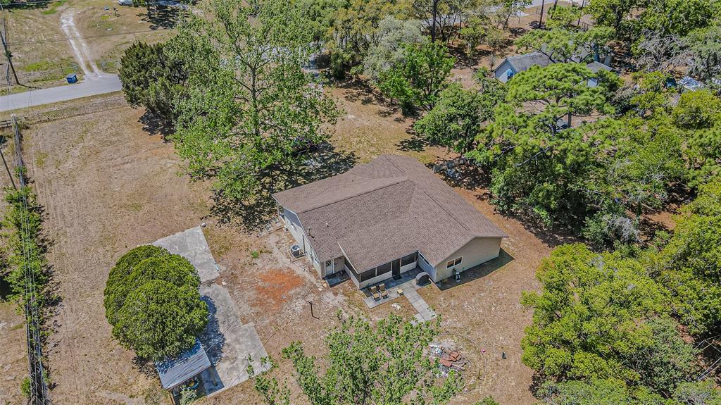 17851 Oxenham Avenue Spring Hill, FL 34610 - Photo 5 of 31 an aerial view of a house with a yard and trees all around