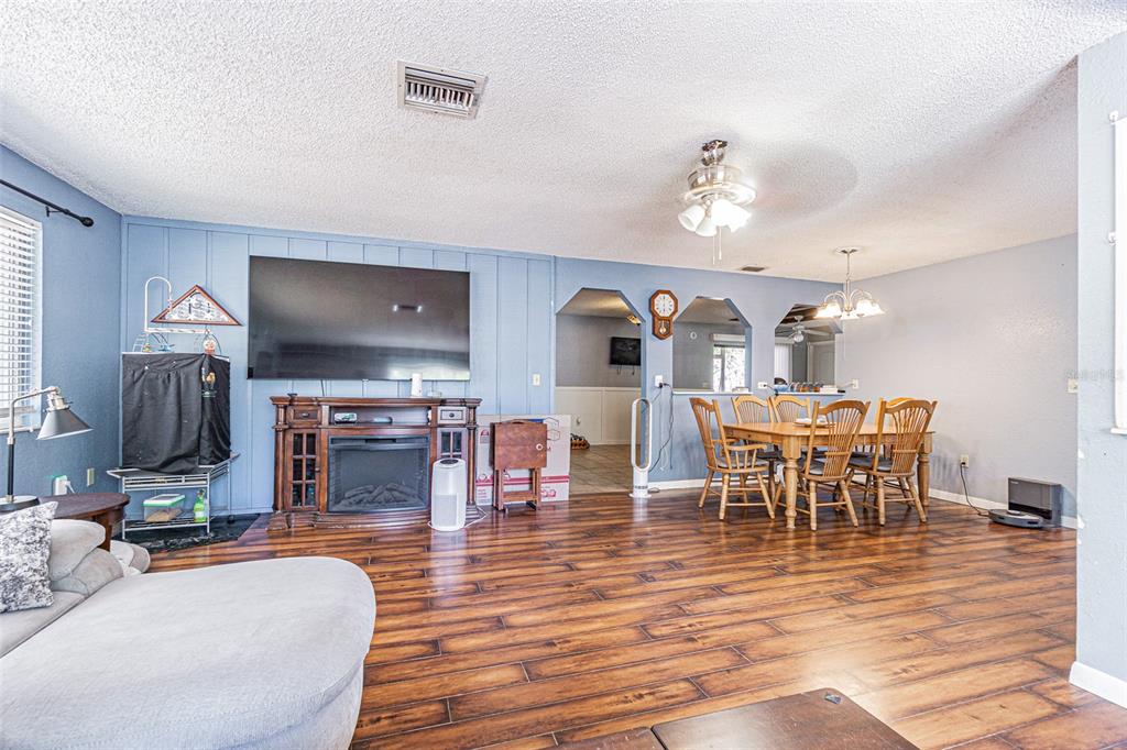 17851 Oxenham Avenue Spring Hill, FL 34610 - Photo 10 of 31 a living room with furniture a dining table and a fireplace