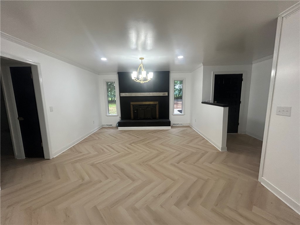 809 Paige Road Honea Path, SC 29654 - Photo 10 of 27 Herringbone flooring and a striking fireplace anchor this inviting, naturally illuminated living space.
