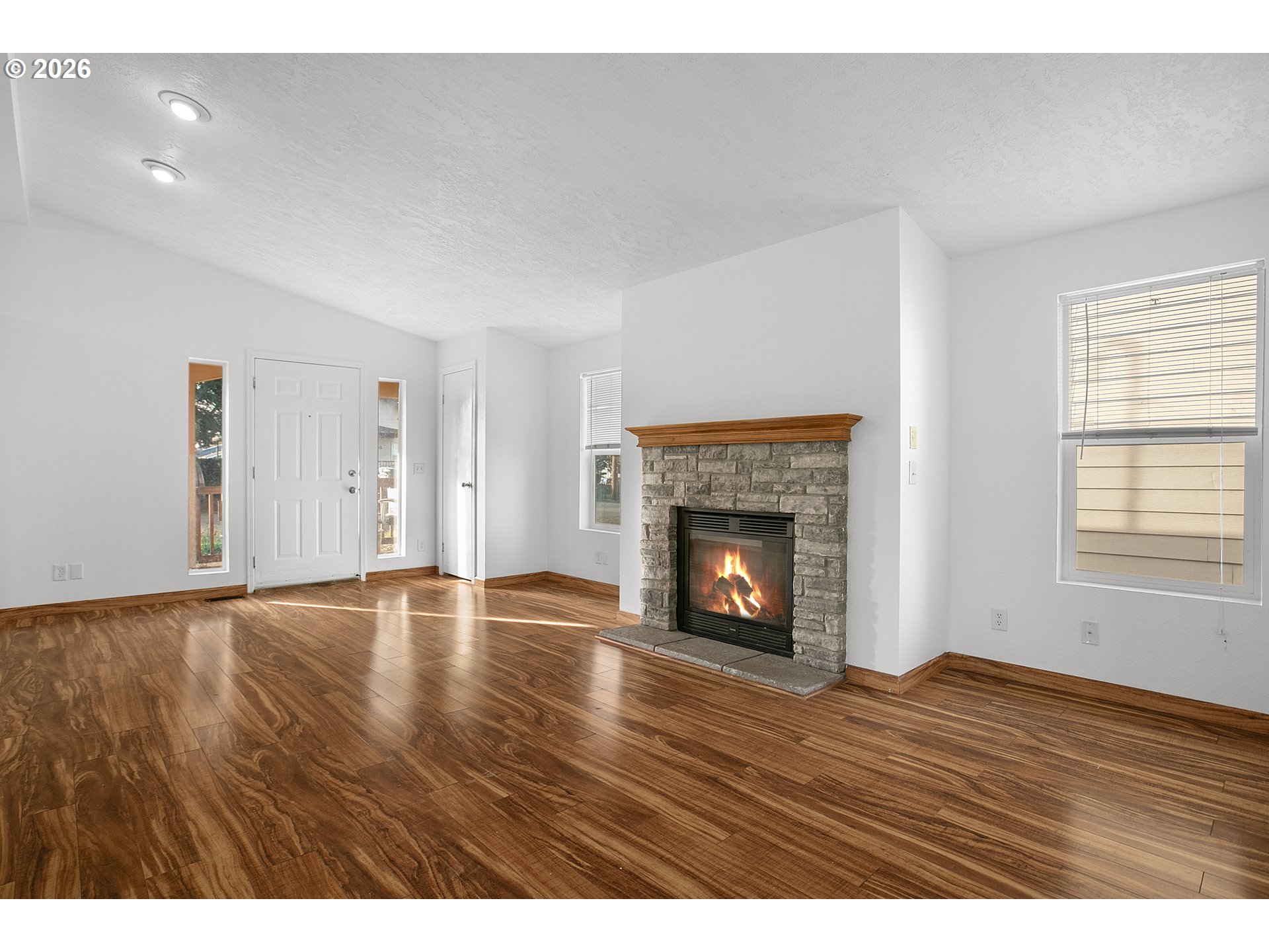 5517 Southeast Lexington Street Portland, OR 97206 - Photo 11 of 29 a view of an empty room with wooden floor fireplace and a window
