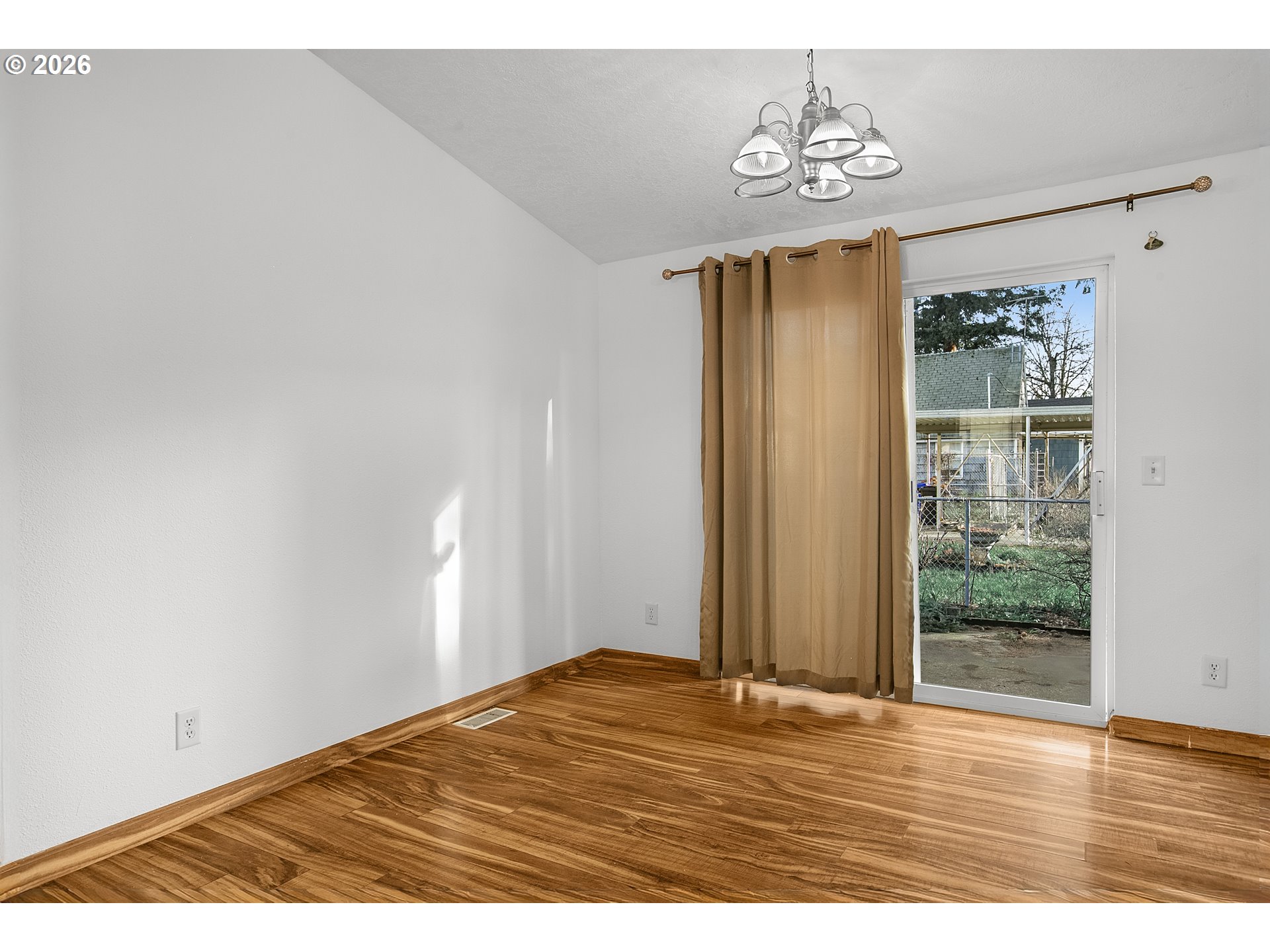 5517 Southeast Lexington Street Portland, OR 97206 - Photo 12 of 29 a view of an empty room with wooden floor and a window