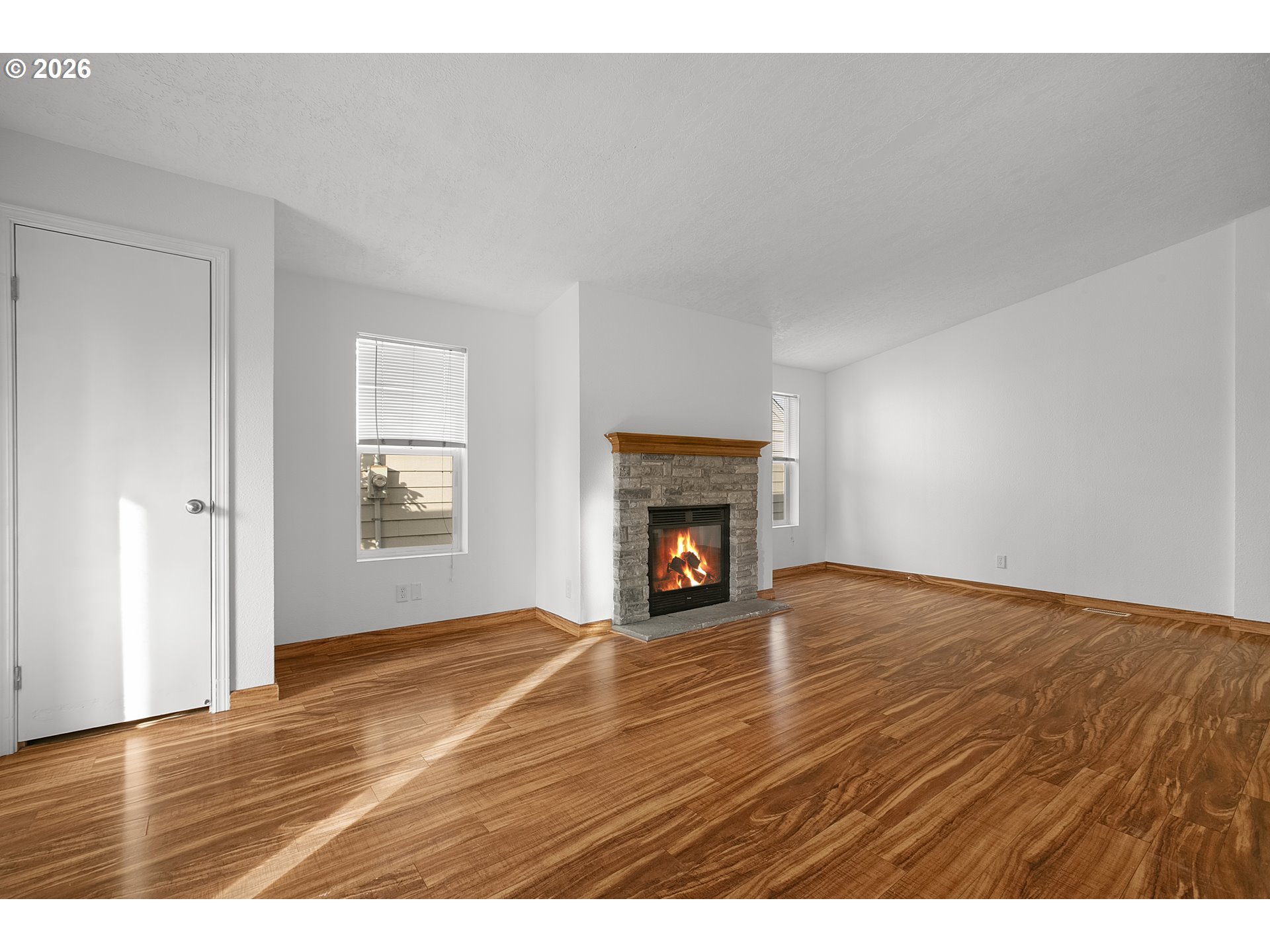 5517 Southeast Lexington Street Portland, OR 97206 - Photo 6 of 29 a view of empty room with wooden floor and fireplace